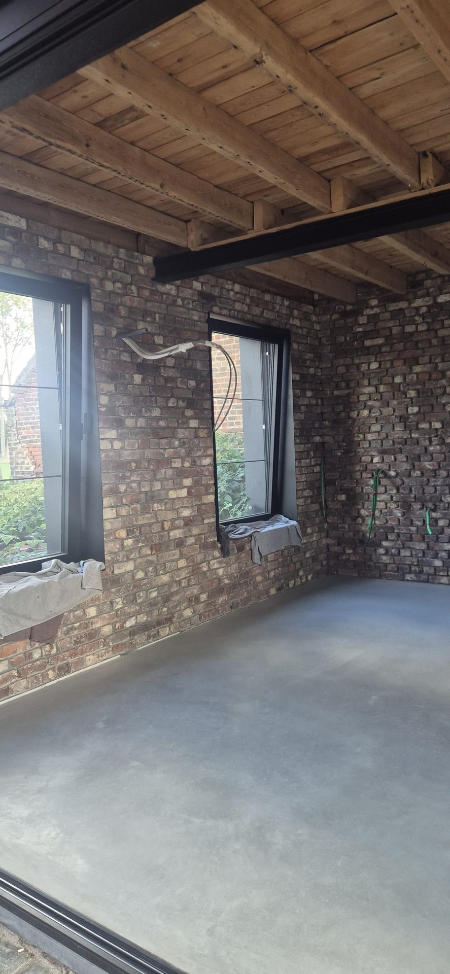 Betonvloer in Glabbeek met authentieke bakstenen muren