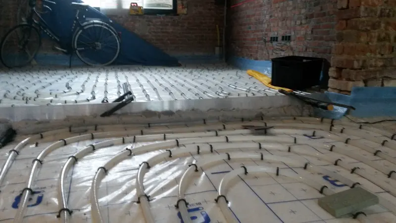 Vloerverwarmingsleidingen op isolatie tijdens de voorbereiding van een woningvloer