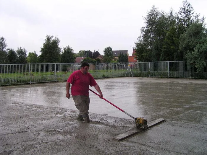 Een medewerker van Glansbeton maakt het verse beton van de parking bij Knaepen vlak