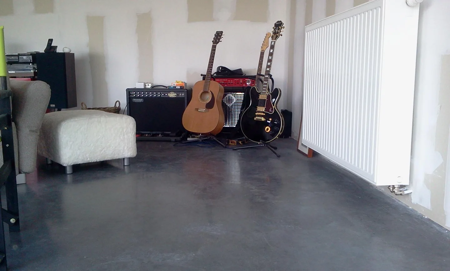 Antraciete betonvloer in een woning in Heist-op-den-Berg met muziekinstrumenten