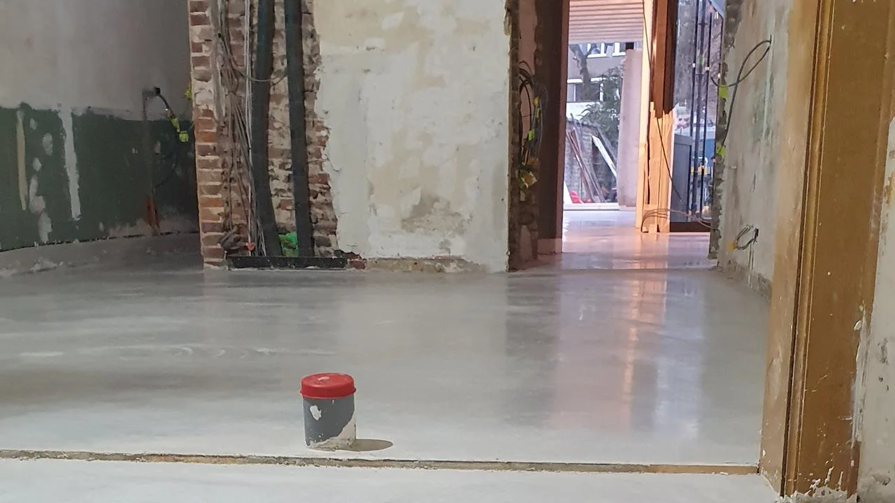 Lichte gepolierde betonvloer naast onafgewerkte wanden