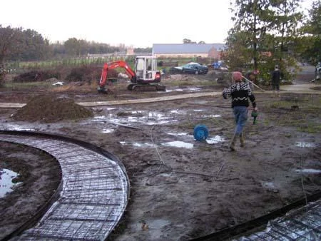 Voorbereide gebogen strook van het tuinpad vóór de verdere betonafwerking