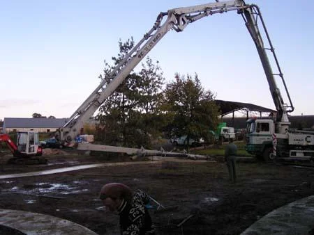 Betonpomp naast de tuin bij de aanleg van het gebogen betonpad