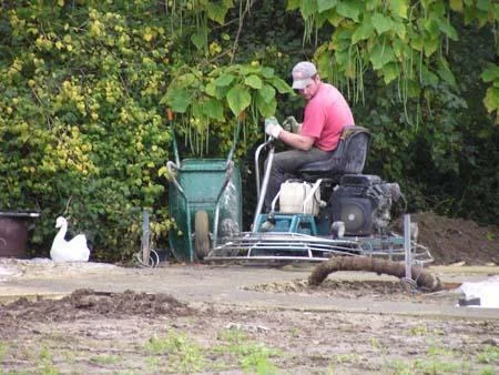 Poliermachine tijdens de afwerking van de betonstrook in de tuin