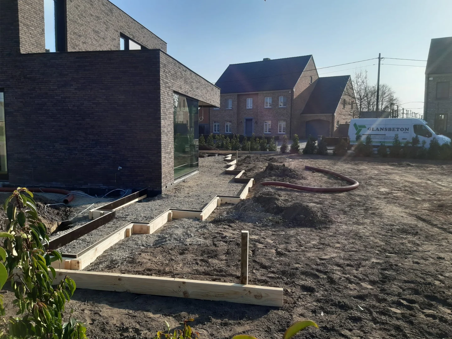 Houten randbekisting uitgezet rond een woning voor het storten van beton