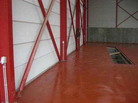 Rode industrievloer bij De Coninck rond de langwerpige uitsparing na het polieren