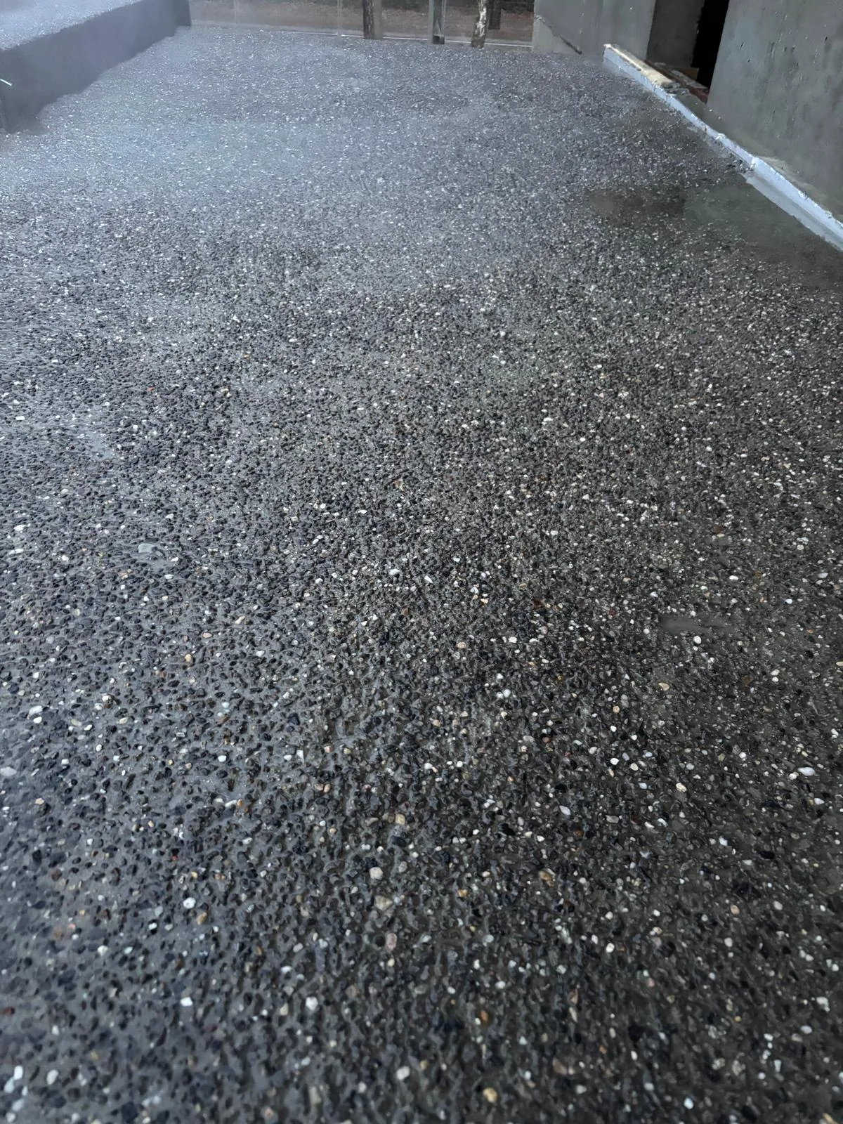 Dark washed concrete floor with visible aggregates at Bosart in Genk